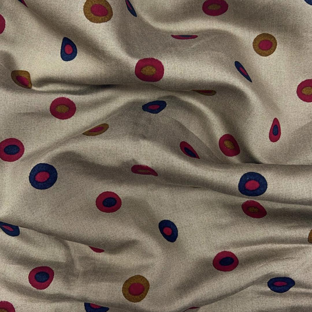 Cream muslin fabric featuring multi-shaded dots in red and blue