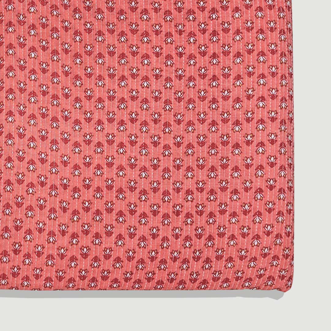 Soft pinkish-orange cotton fabric adorned with small floral Kantha stitching, offering a touch of artisanal beauty at Fabrics @StudioLCX.