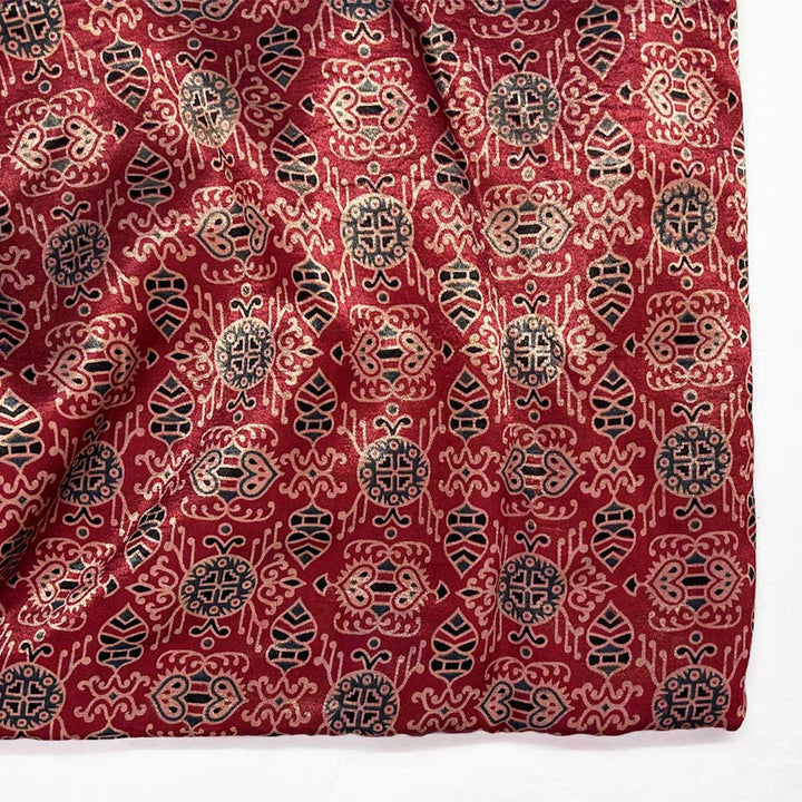 Exquisite maroon patola printed ajrakh mashru silk fabric, combining timeless patterns with sumptuous texture for luxurious garments.