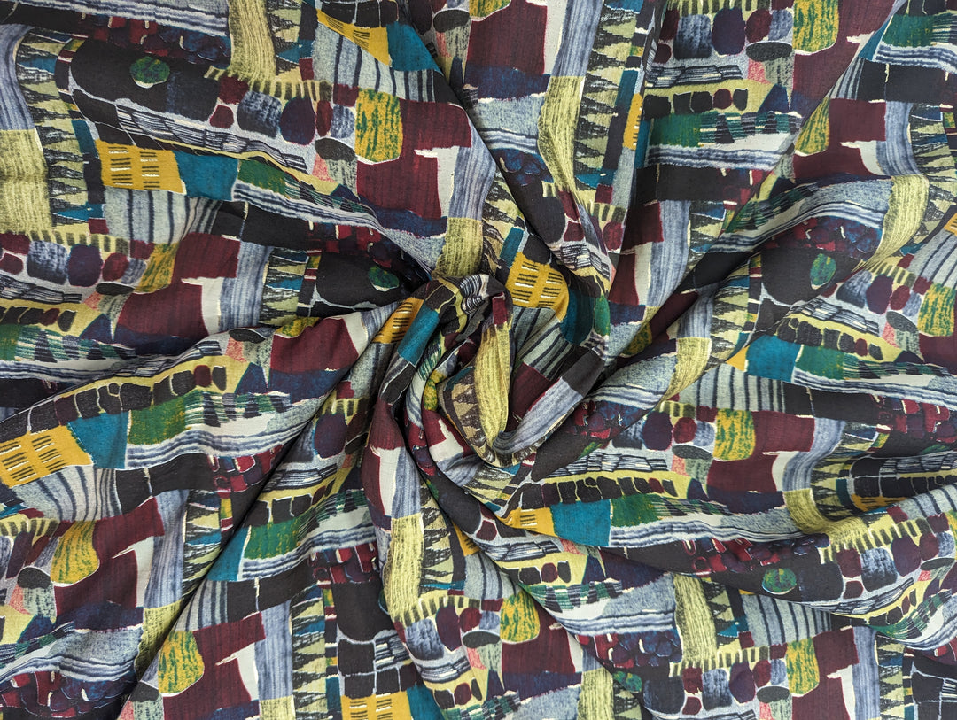 Artistic geometric multicolor print on soft muslin fabric, perfect for making statement clothing with a splash of colors.