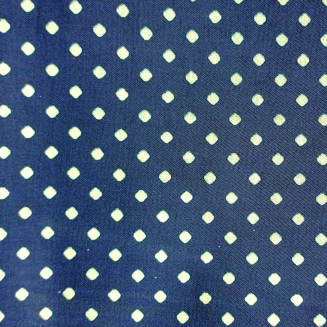 Chic navy blue georgette fabric with playful white polka dots, ideal for stylish garments at Fabrics @StudioLCX.