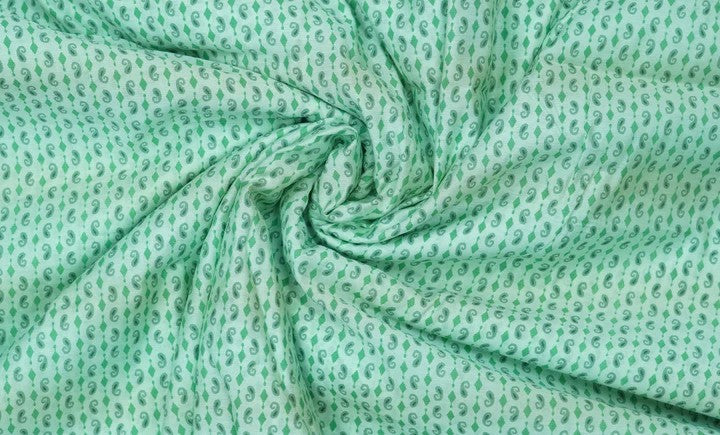 Swirling light green paisley on muslin fabric